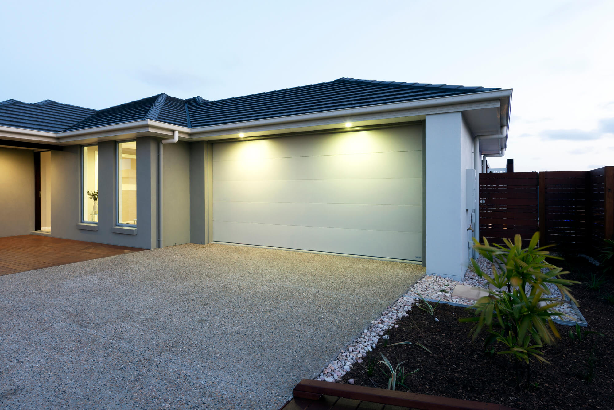 Front of house at dusk showing garage door and driveway
